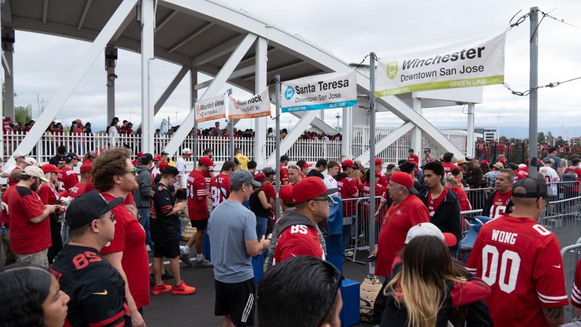 Niner football fans waiting in the VTA queue lines to board the light rail after a Niner game.