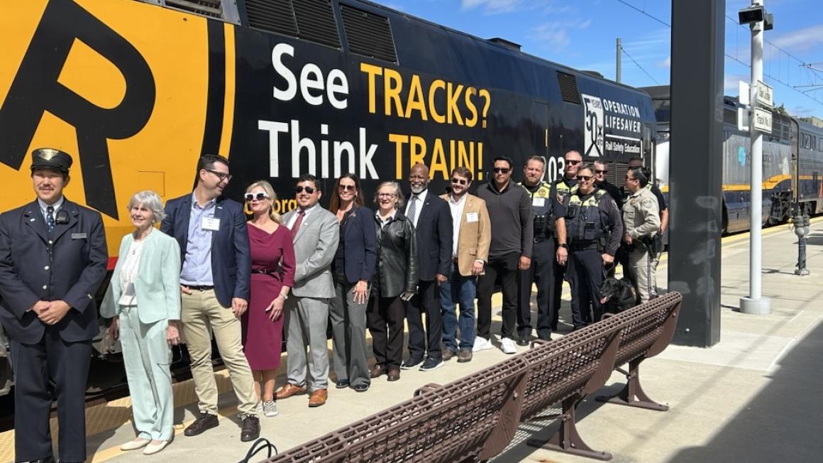 See Tracks, Think Train wrap on train with transit professionals posing in front of it.