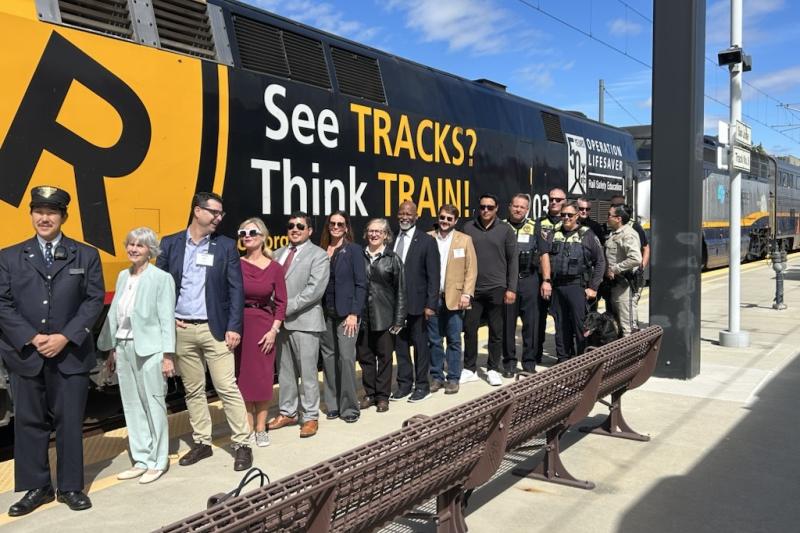 See Tracks, Think Train wrap on train with transit professionals posing in front of it.