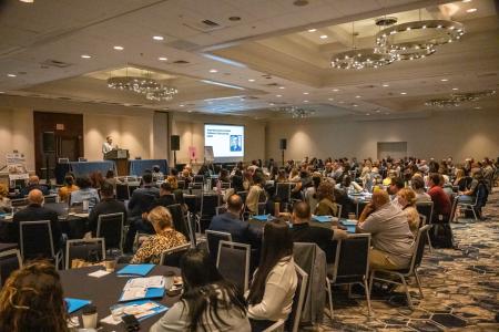 hundreds of people sitting in a conference room 