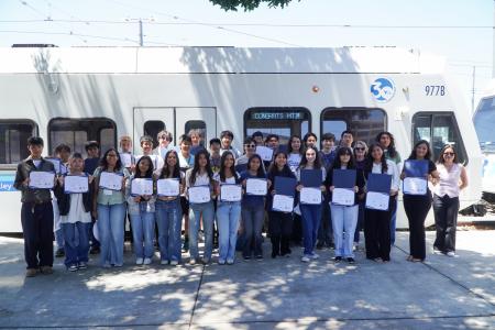 Mineta Transportation Institute summer program high school students' group photo with their certificates in front of the VTA light rail train
