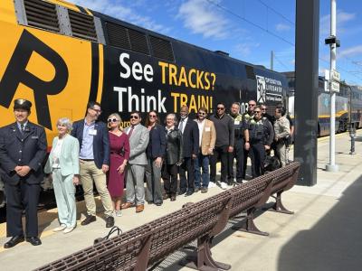 See Tracks, Think Train wrap on train with transit professionals posing in front of it.