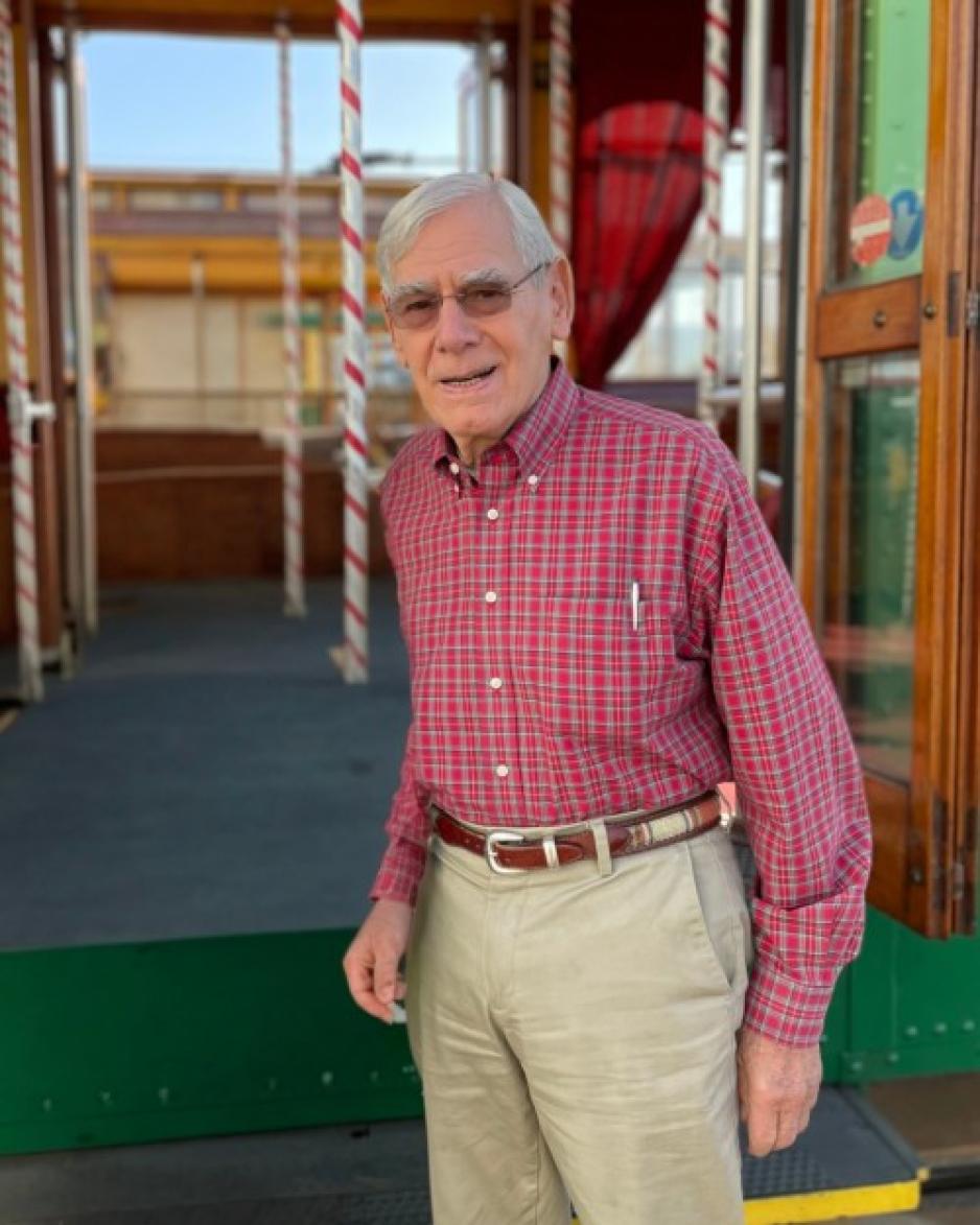 Rod Diridon, Sr. in red shirt and khakis in front of historic trollie